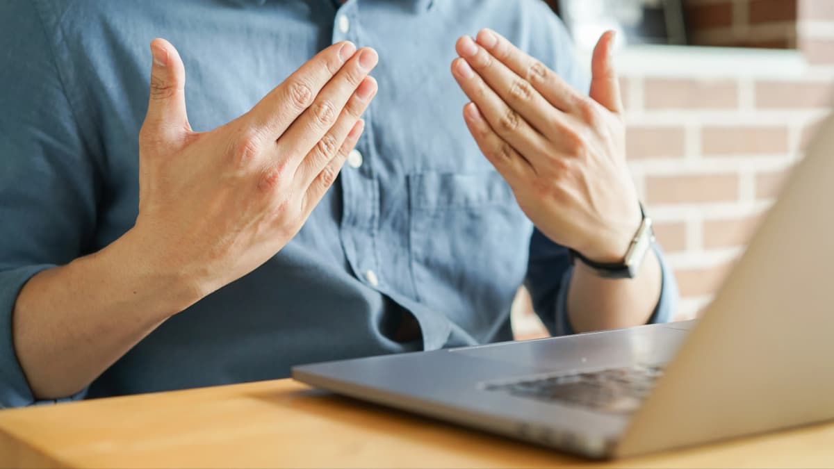 Interpreter communicating in Sign Language on laptop.