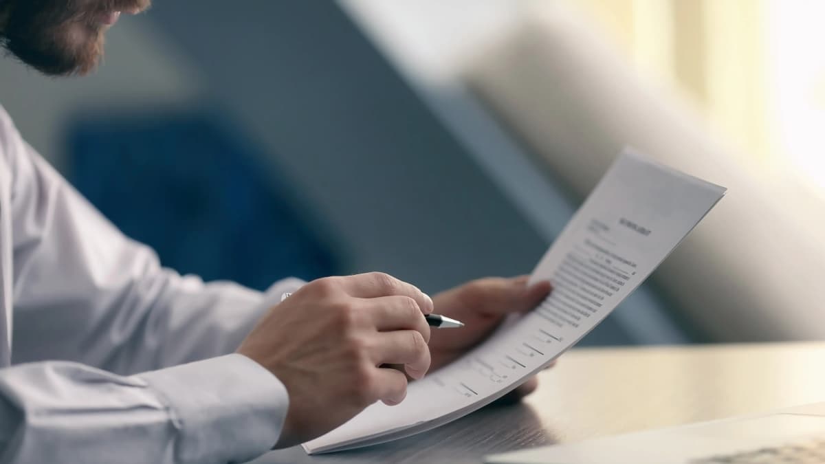 Attorney holding a pen and reviewing a deposition summary.