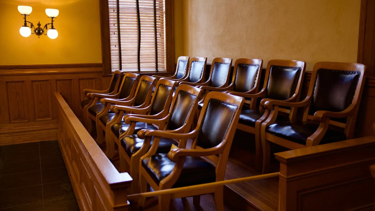 Empty jury chairs in a courtroom.