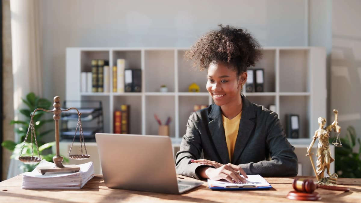 African American woman paralegal working in office on laptop.